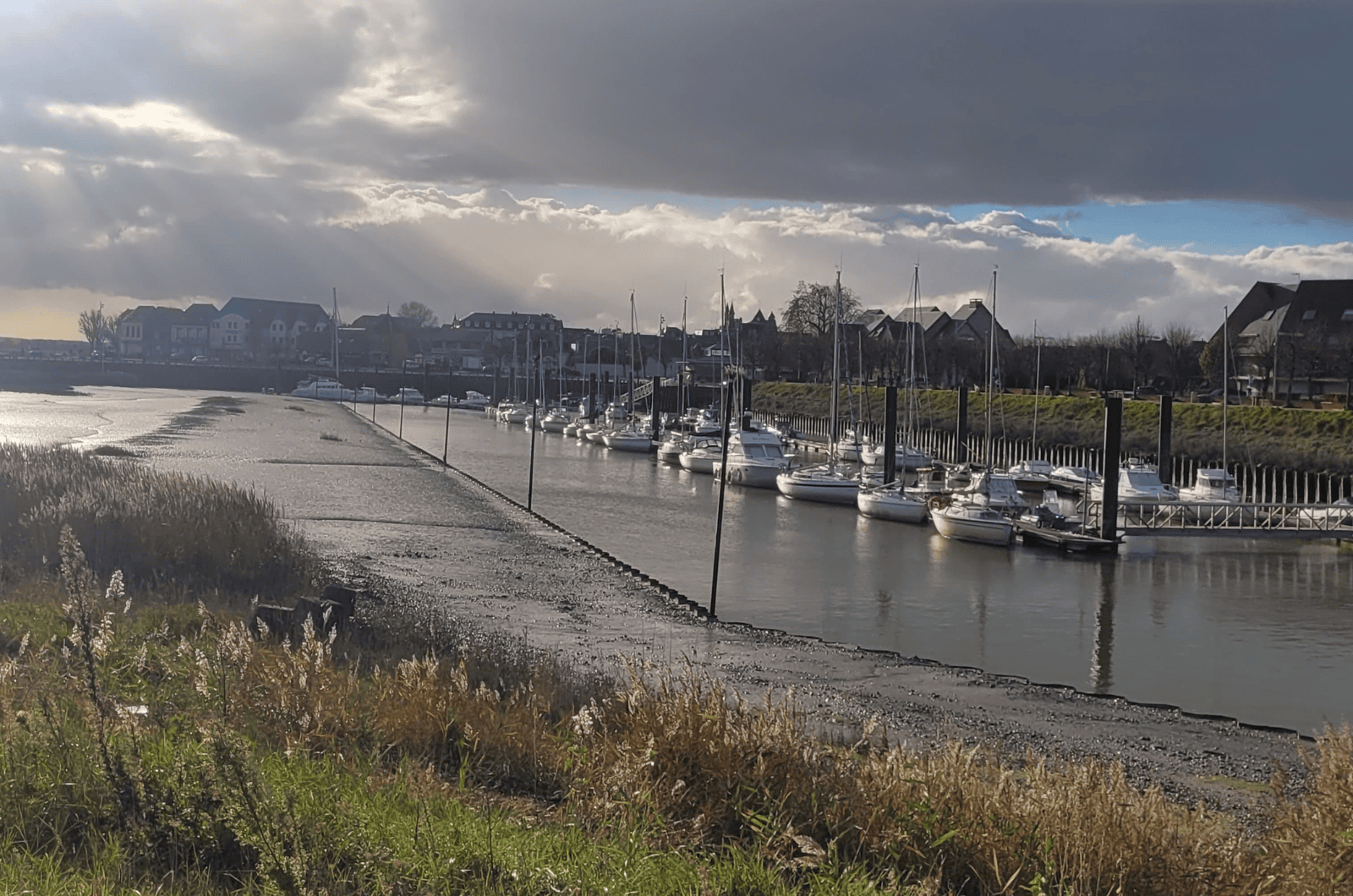 Promenade en bord de mer du Crotoy, digue piétonne et maisons face à la baie.